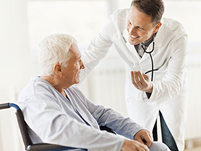 Long-Term Care Facilities: A doctor speaking with an elderly man in a wheelchair